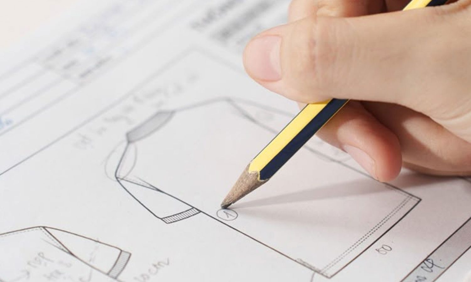 Hand sketching a shirt design on pattern paper